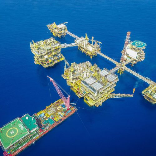 Aerial shot of an offshore oil platform complex in the ocean, showcasing industrial infrastructure.